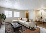 Thumbnail 1 of 29 - A living room with a white couch and a black coffee table. Omaha, NE Stony Brook Apartments