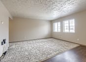 Thumbnail 13 of 29 - A room with a carpeted floor and two windows. Omaha, NE Stony Brook Apartments