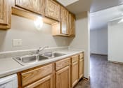 Thumbnail 16 of 29 - A kitchen with wooden cabinets and a white dishwasher. Omaha, NE Stony Brook Apartments