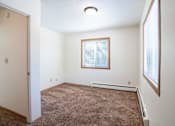 Thumbnail 16 of 20 - A room with a brown carpet and a window. Fargo, ND Morningside Apartments