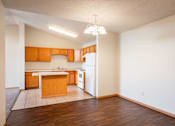 Thumbnail 12 of 43 - A kitchen with wooden cabinets and a white refrigerator. Bismarck, ND Sierra Ridge Apartments