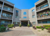Thumbnail 29 of 29 - an exterior view of an apartment building with a sidewalk and potted plants