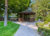 Thumbnail 26 of 29 - Anoka, MN Dellwood Estates Apartments. a gazebo in a park with trees