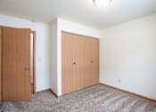 Thumbnail 24 of 30 - A room with two doors and a carpeted floor. Fargo, ND Long Island Apartments