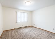 Thumbnail 25 of 30 - A room with a carpeted floor and a window with blinds. Fargo, ND Long Island Apartments