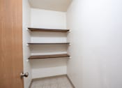 Thumbnail 27 of 30 - A white hallway with a brown door and three shelves. Fargo, ND Long Island Apartments