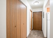 Thumbnail 28 of 30 - A hallway with a wooden door on the left and a brown door on the right. Fargo, ND Long Island Apartments