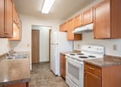 Thumbnail 21 of 30 - A kitchen with brown cabinets and white appliances. Fargo, ND Long Island Apartments