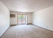 Thumbnail 13 of 21 - A room with a carpeted floor and a window with a view of a fence. Fargo, ND West Oak Apartments