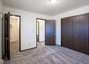 Thumbnail 19 of 23 - A room with a carpeted floor and three doors. West Fargo, ND Parkwest Gardens