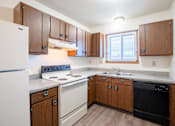 Thumbnail 16 of 23 - A kitchen with wooden cabinets and a white refrigerator. West Fargo, ND Parkwest Gardens