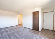 Thumbnail 14 of 23 - A room with a carpet and a brown door. West Fargo, ND Parkwest Gardens