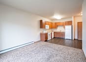 Thumbnail 10 of 24 - A kitchen with white appliances and wooden cabinets. Fargo, ND North Sky II Apartments