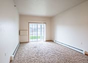 Thumbnail 9 of 24 - A room with a carpet floor and a sliding glass door. Fargo, ND North Sky II Apartments
