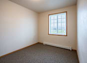 Thumbnail 6 of 24 - A room with a window and a radiator on the floor. Fargo, ND North Sky II Apartments