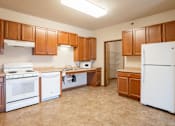 Thumbnail 4 of 24 - A kitchen with white appliances and wooden cabinets. Fargo, ND North Sky II Apartments