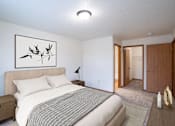 Thumbnail 7 of 25 - A bedroom with a bed, nightstand, lamp, and a framed picture on the wall. Fargo, ND Park Place Apartments