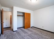 Thumbnail 42 of 43 - A room with a carpeted floor and a wooden door. Fargo, ND Islander Apartments