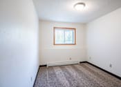 Thumbnail 39 of 43 - A room with a window and a carpeted floor. Fargo, ND Islander Apartments