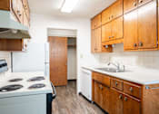 Thumbnail 36 of 43 - A kitchen with wooden cabinets and a white counter top. Fargo, ND Islander Apartments