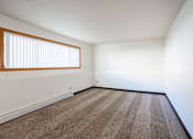 Thumbnail 34 of 43 - A room with a carpeted floor and a window with blinds. Fargo, ND Islander Apartments