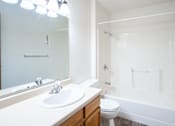 Thumbnail 15 of 17 - A white bathroom with a sink, toilet, and bathtub. Fargo, ND Hazelwood Townhomes