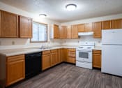 Thumbnail 8 of 17 - A kitchen with wooden cabinets and white appliances. Fargo, ND Hazelwood Townhomes