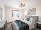Thumbnail 3 of 10 - A bedroom with a bed, nightstand, and window. Fargo, ND Hawthorn Apartments