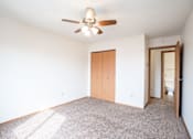 Thumbnail 7 of 10 - A room with a ceiling fan and a carpeted floor. Fargo, ND Hawthorn Apartments
