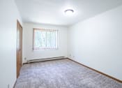 Thumbnail 27 of 39 - A room with a window and a carpeted floor. Grand Forks, ND Columbia West Apartments