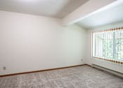 Thumbnail 31 of 39 - A room with a window and a carpeted floor. Grand Forks, ND Columbia West Apartments