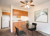 Thumbnail 2 of 10 - A kitchen with a table and chairs and a ceiling fan. Fargo, ND Hawthorn Apartments