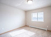 Thumbnail 17 of 20 - A room with a window and a carpet on the floor. Fargo, ND East Bridge Apartments