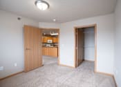 Thumbnail 18 of 20 - A room with a carpeted floor and a wooden door. Fargo, ND East Bridge Apartments