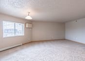 Thumbnail 12 of 20 - A room with a window and a carpeted floor. Fargo, ND East Bridge Apartments