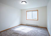 Thumbnail 9 of 14 - A room with a window and a carpet on the floor. Fargo, ND Crown Court 2 Apartments