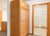 Thumbnail 12 of 14 - A wooden wardrobe with a mirror on the door stands in a room. Fargo, ND Crown Court 2 Apartments