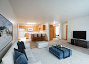 Thumbnail 2 of 14 - A modern living room with a white couch and a blue coffee table. Fargo, ND Crown Court Apartments