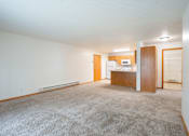Thumbnail 6 of 14 - A carpeted room with a desk and a refrigerator. Fargo, ND Crown Court 2 Apartments