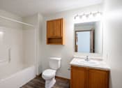 Thumbnail 38 of 43 - A white toilet sits next to a sink in a small bathroom. Bismarck, ND Sierra Ridge Apartments