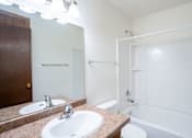 Thumbnail 12 of 14 - A bathroom with a toilet, sink, and bathtub. Fargo, ND Park Terrace Apartments