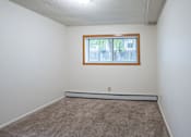 Thumbnail 10 of 14 - A room with a window and carpeted floor. Fargo, ND Park Terrace Apartments