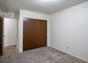 Thumbnail 11 of 14 - A room with a brown door and carpeted floor. Fargo, ND Park Terrace Apartments