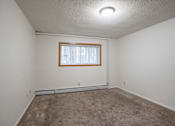 Thumbnail 8 of 14 - A room with a window and carpeted floor. Fargo, ND Park Terrace Apartments