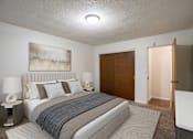 Thumbnail 6 of 14 - A bedroom with a large bed and a painting on the wall. Fargo, ND Park Terrace Apartments