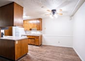 Thumbnail 5 of 14 - A kitchen with wooden cabinets and a ceiling fan. Fargo, ND Park Terrace Apartments