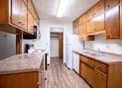 Thumbnail 7 of 14 - A kitchen with wooden cabinets and a granite counter top. Fargo, ND Park Terrace Apartments