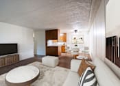 Thumbnail 2 of 14 - A modern living room with a white couch and a television. Fargo, ND Park Terrace Apartments