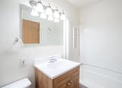 Thumbnail 16 of 28 - A white sink in a wooden cabinet under a mirror. West Fargo, ND Sheyenne Terrace Townhomes