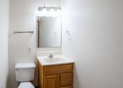 Thumbnail 17 of 28 - A white toilet sits next to a sink in a small bathroom. West Fargo, ND Sheyenne Terrace Townhomes